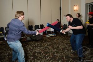 Two Penguicon-goers in a mock battle with foam swords