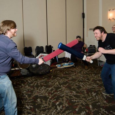 Two Penguicon-goers in a mock battle with foam swords